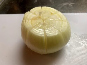 玉ねぎの皮を剥き、十字に隠し包丁を入れる