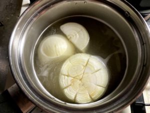 水を張った鍋に玉ねぎとコンソメキューブを入れ、蓋をして火にかける